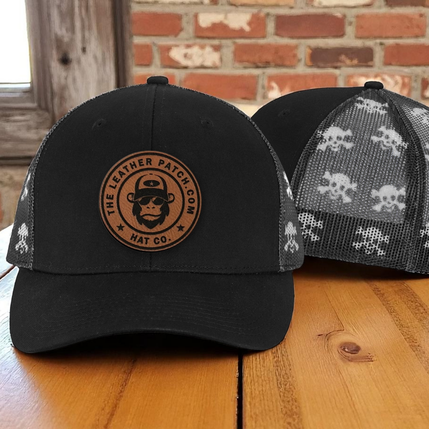A black baseball cap with a circular logo on the front, featuring a monkey wearing sunglasses and the text "The Leather Patch Co Hat Co."