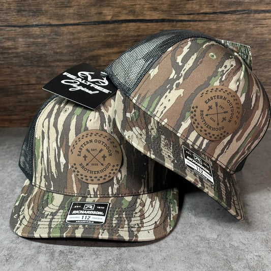 two camouflage-patterned baseball caps with a tag attached to one of them.