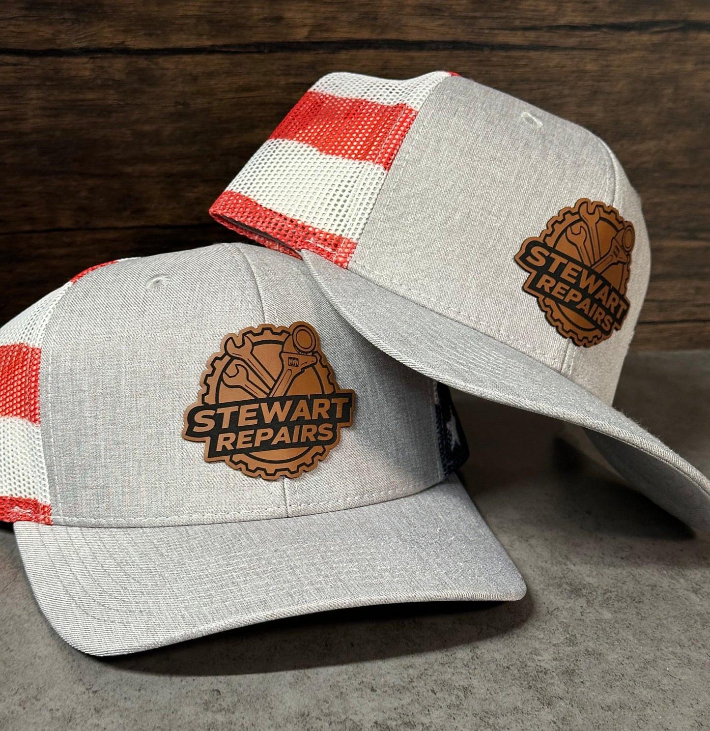 Two gray caps with red and white striped interior on a wooden surface


