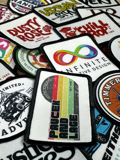 a collection of various patches or logos, including a patch with a rainbow-colored design and the text &quot;Infinite Design&quot;.