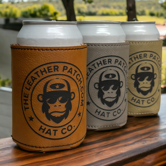 Three tan and white can holders with a monkey logo printed on them, placed on a wooden surface.