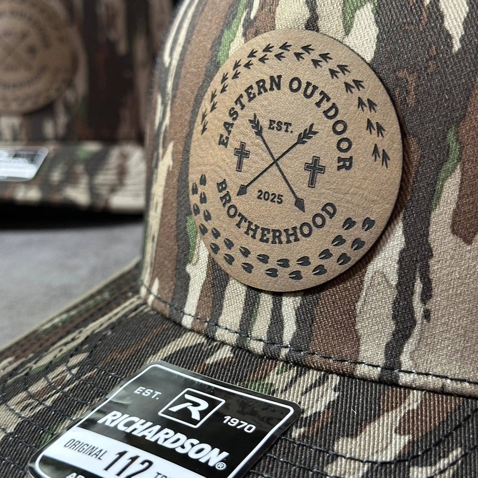 a close-up view of a camouflage-patterned fabric, with a circular logo or badge prominently displayed on it.