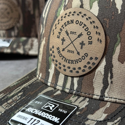 a close-up view of a camouflage-patterned fabric, with a circular logo or badge prominently displayed on it.